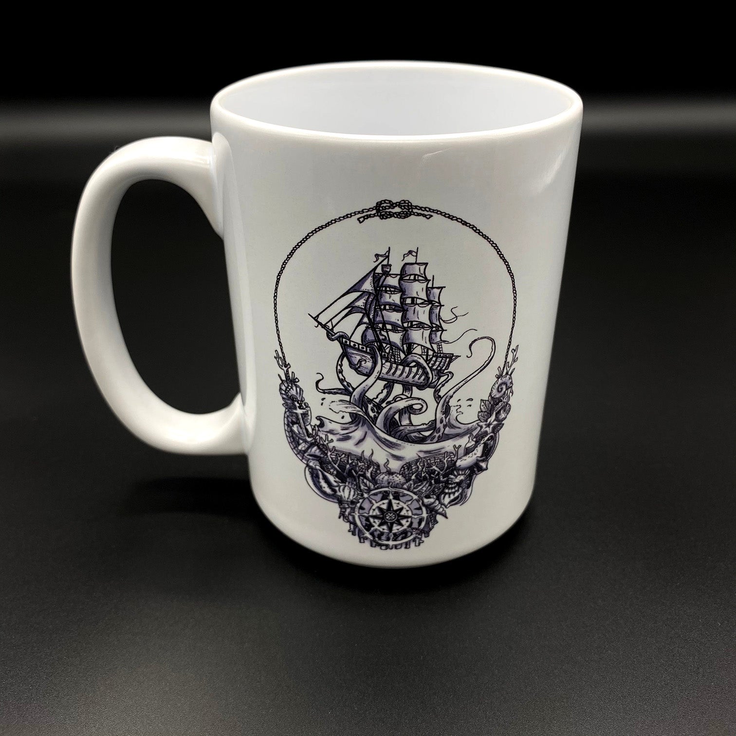 A white ceramic cup with lost sailor logo from Earth Kind Designs TM